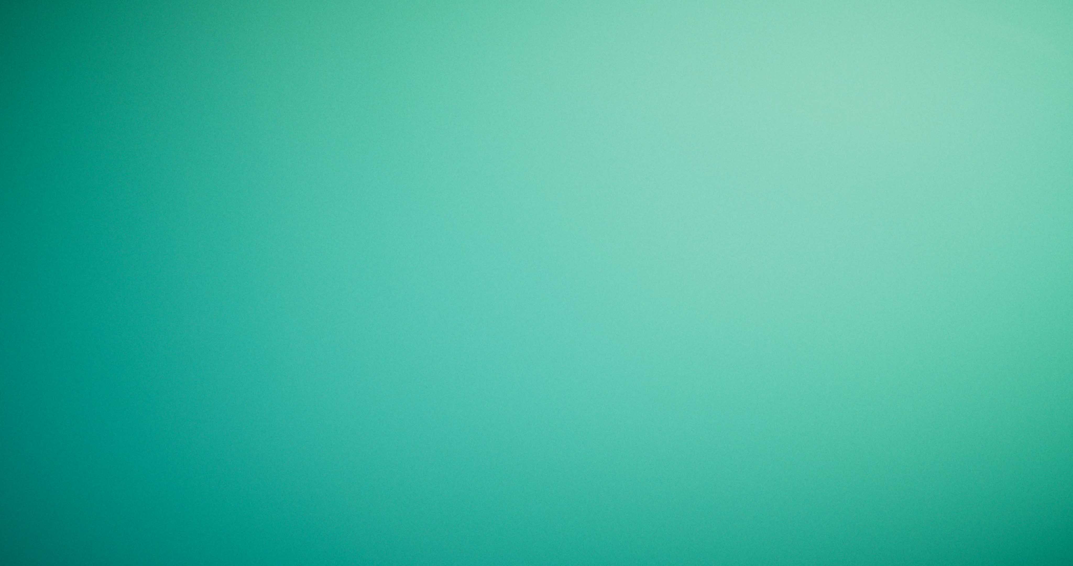 Front-facing Porsche GT3 with headlights on, carving through a chicane at twilight in alpine scenery.